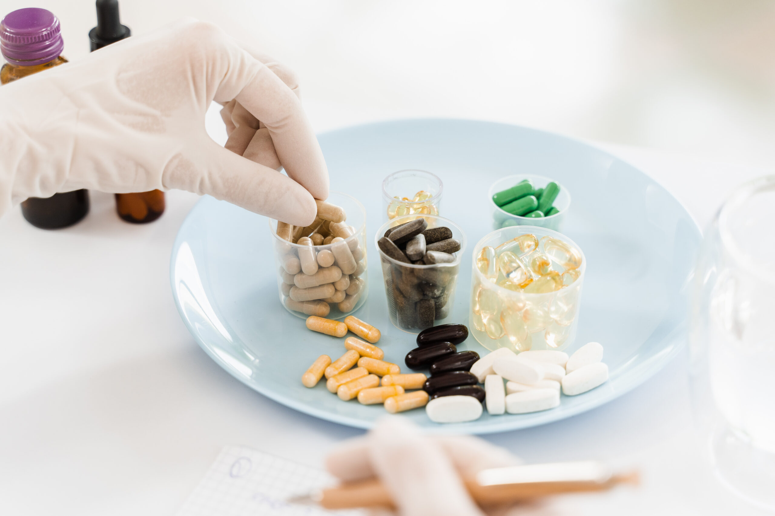 Nutritionist holding biologically active supplements tablets in gloves and help patient to plan daily diet. Pills for health care. Recommendation for daily dietary. 化療營養品推薦全攻略 — 17種市售癌症專用配方大評比/2026最新